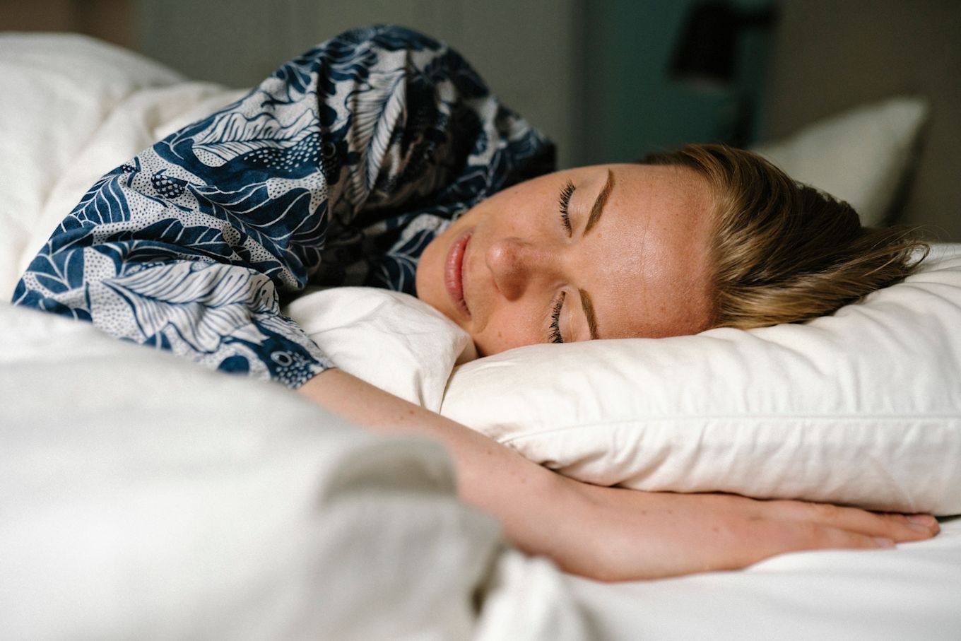 Kvinna ligger i sängen och sover.