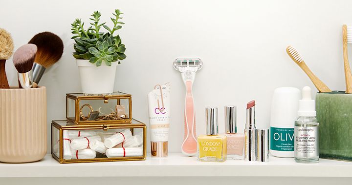 En hylla med många skönhetsprodukter. Sminkborstar, rakhyvel, nagellack, läppstift, tandborstar.