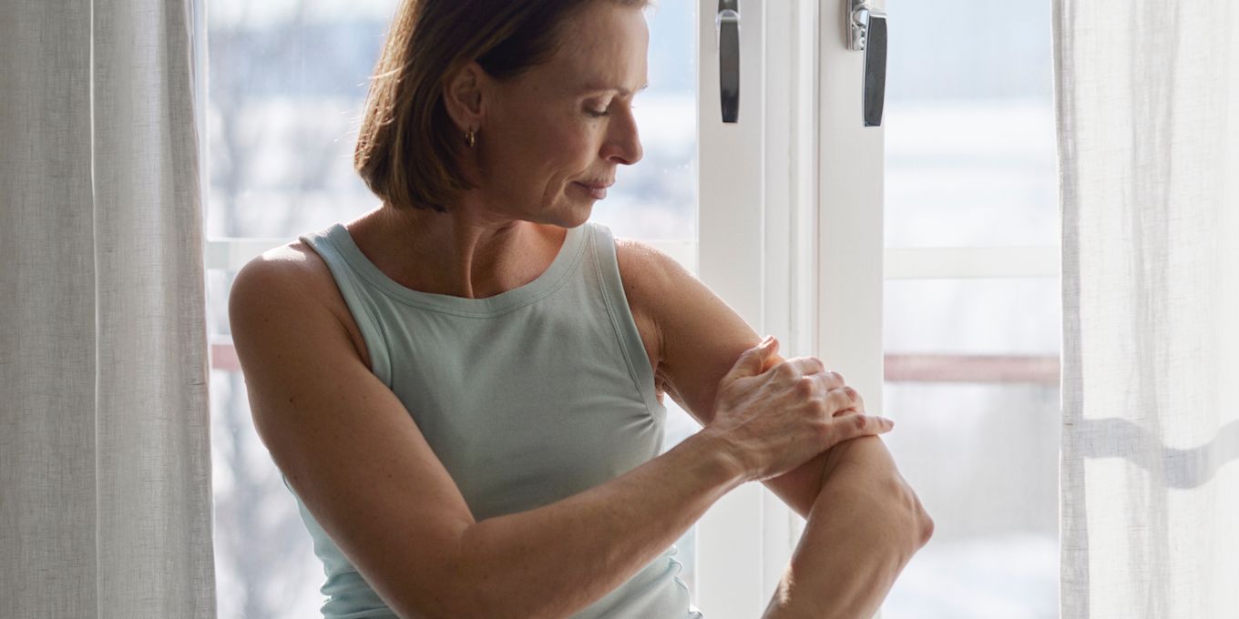 Kvinna smörjer in sin ena arm.